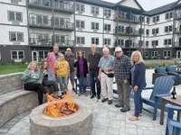 Delightful outdoor gathering, featuring residents enjoying a cozy fire pit area with comfy seating in the courtyard of a modern apartment complex.