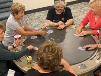 Engaging social scene with a group of friends enjoying a lively card game around a stylish poker table.