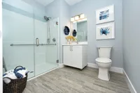 Bright modern bathroom with elegant walk-in shower, stylish vanity, and calming blue accents.