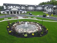 Elegant apartment complex with modern design, featuring beautifully landscaped gardens and a serene fountain for a tranquil living environment.