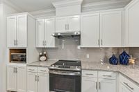 Bright, modern kitchen with sleek white cabinetry, stainless steel appliances, and elegant granite countertops.