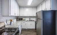 Newly Renovated Kitchen with stainless steel apartments, white cabinets, and subway tile backsplash