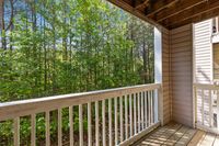 Charming apartment balcony with serene forest view, perfect for nature lovers seeking tranquility.
