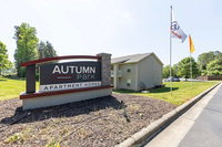 Inviting entrance to Autumn Park Apartment Homes surrounded by lush greenery and modern architecture.