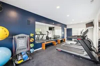 Modern fitness room featuring state-of-the-art treadmills, exercise equipment, and vibrant wall colors, perfect for an energizing workout.