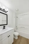 Elegant bathroom with modern fixtures, featuring a sleek white vanity, stylish black mirror, and inviting bathtub.