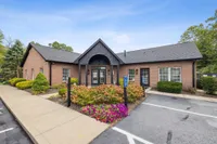 Charming brick community center with beautifully manicured landscaping and ample parking.