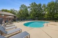 Inviting outdoor pool area with comfortable lounge chairs and a serene natural backdrop for ultimate relaxation.
