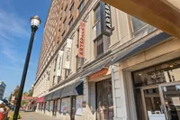 Charming urban street view showcasing a historic brick building with prominent leasing signs, offering luxury homes at Artspace 323.