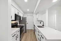 Modern kitchen with sleek appliances, bright white cabinetry, and elegant countertops in an inviting open layout.