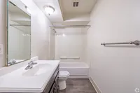 Modern bathroom featuring sleek fixtures, a spacious vanity, and a pristine bathtub with light, inviting decor.