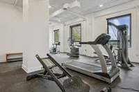 Bright and modern fitness center with state-of-the-art equipment, including a treadmill, stationary bike, and weight training machines.