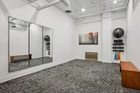 Modern fitness studio with mirrored wall, elegant workout equipment, and stylish decor.