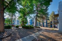 Scenic apartment complex with lush greenery and stone pathways in a serene natural setting.