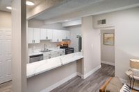 Modern kitchen with sleek white cabinetry, stainless steel appliances, and elegant marble countertops in a bright, inviting space.