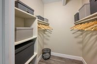 Luxurious walk-in closet with ample shelving, elegant hangers, and sleek storage boxes, perfect for organizing in style.