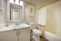 Elegant and modern bathroom featuring a stylish vanity with a marble countertop, a framed mirror, and a chic shower curtain for a sophisticated touch.