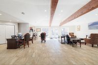 Elegant and spacious office lounge with stylish wooden furniture, large windows, and natural light enhancing the cozy ambiance.