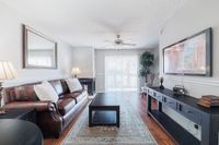 Inviting living room with a plush leather sofa, elegant decor, and large windows offering abundant natural light. Ideal for relaxation and entertaining.