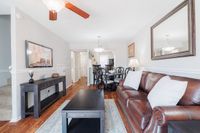 Bright living area with a luxurious leather sofa, elegant dining set, and stylish decor, perfect for entertaining.