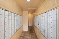 Welcoming apartment mailroom with secure, organized mailboxes against a warm, wood-paneled backdrop.