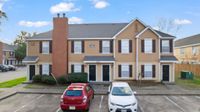Charming duplex exterior with a modern design and ample parking in a peaceful neighborhood.
