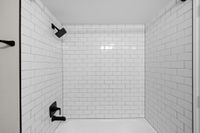 Modern bathroom showcasing sleek matte black fixtures and pristine white subway tiles for a stylish and contemporary look.