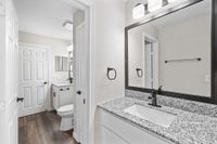Chic bathroom showcasing a sleek granite countertop, modern fixtures, and elegant lighting, perfect for luxurious living.