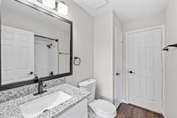 Sleek modern bathroom featuring a granite countertop, elegant fixtures, and a pristine shower with subway tiles.