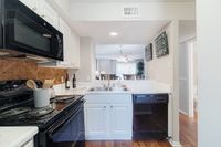 Bright and inviting kitchen with modern appliances, elegant countertops, and a glimpse into a cozy dining area.