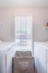 Bright, modern laundry room with large window, washing machine, and convenient shelving.