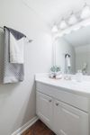 Bright and modern bathroom with elegant vanity, large mirror, and soft lighting creating a cozy ambiance.