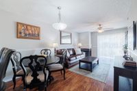 Charming open-plan living and dining area with stylish furniture, elegant lighting, and abundant natural light from large windows.