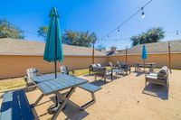 Inviting outdoor patio with cozy seating, shaded tables, and charming string lights, perfect for entertaining and relaxation.