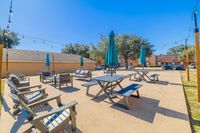 Charming outdoor patio with stylish seating, vibrant umbrellas, and enchanting string lights, perfect for relaxation and gatherings.