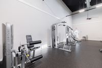 Modern and spacious gym with state-of-the-art fitness equipment and high ceilings, perfect for an invigorating workout.