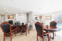 Elegant office space with classic wooden furniture, featuring a spacious desk, comfortable seating, and a view of the pool.