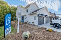 Welcoming townhome entrance at Chestnut Heights with open house sign, lush greenery, and elegant exterior design.