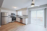 Bright, modern kitchen with stainless steel appliances, granite countertops, and stylish laminate flooring, leading to an inviting patio view.
