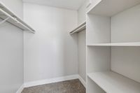 Spacious walk-in closet with ample shelving and hanging space, perfect for organized living.