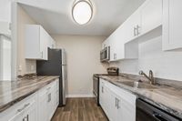 Contemporary kitchen with sleek stainless steel appliances, elegant white cabinetry, and modern countertops, boasting a stylish and functional design.