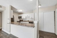 Modern kitchen with sleek countertops, stainless steel appliances, and elegant white cabinetry, perfect for culinary enthusiasts.