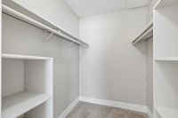 Spacious walk-in closet with ample shelving and a sleek design, perfect for organized storage.