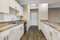 Chic modern kitchen with sleek granite countertops, white cabinetry, and elegant hardwood flooring.