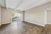 Bright and spacious living room with modern wooden flooring and large windows offering plenty of natural light.