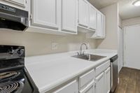 Modern kitchen with sleek white cabinetry, polished countertops, and stainless steel appliances.