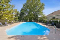 Inviting outdoor pool area surrounded by lush greenery and comfortable lounge chairs, perfect for relaxation and enjoying sunny days.