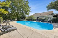 Inviting outdoor pool area surrounded by lush greenery and comfortable lounge chairs, perfect for relaxation and leisure.