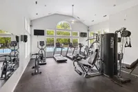 Modern fitness center with state-of-the-art exercise equipment and large windows offering scenic outdoor views.