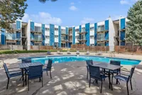 Inviting apartment complex with a refreshing pool, modern architecture, and outdoor seating area, perfect for relaxation and leisure.